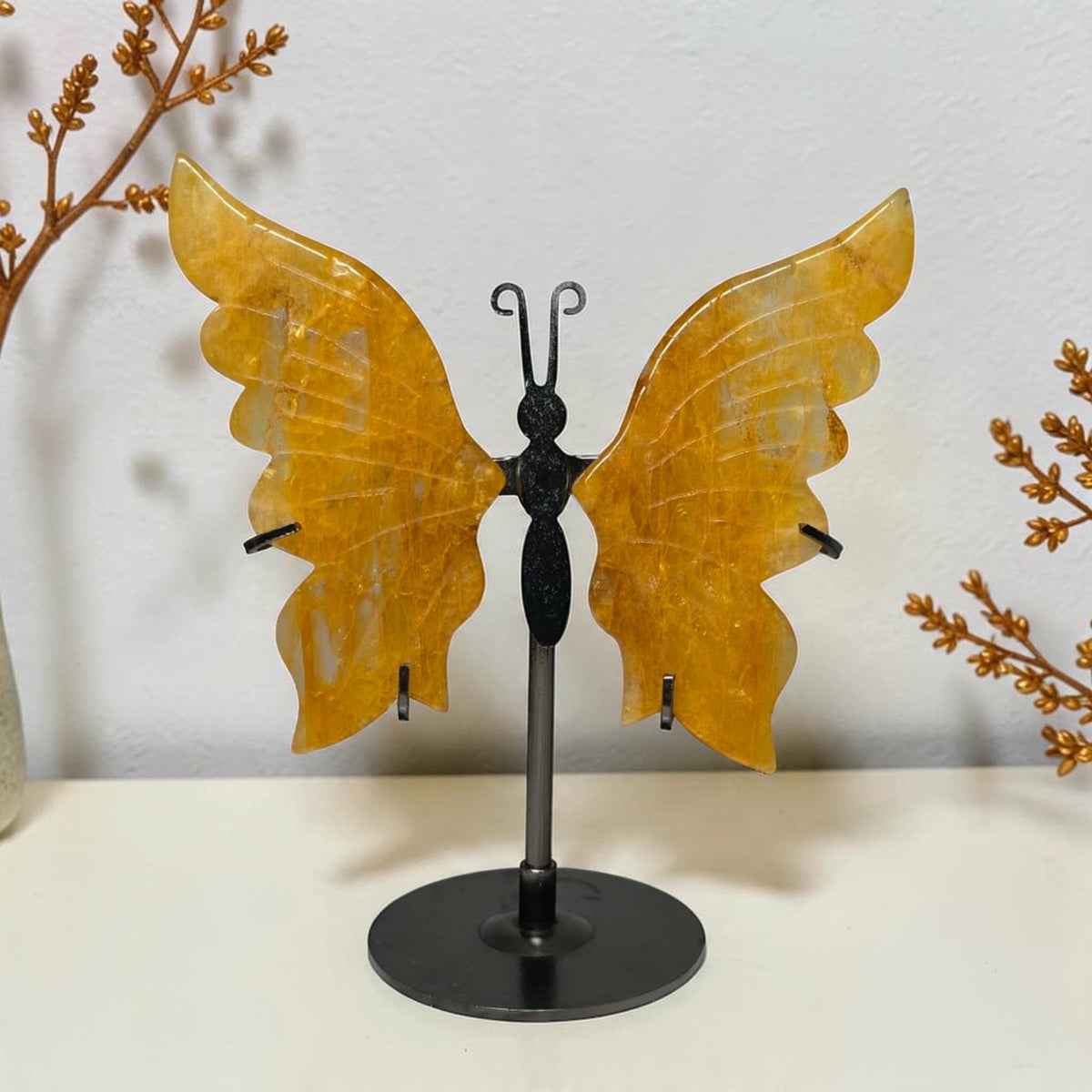 Small Golden Healer quartz butterfly with yellow wings on a black round stand