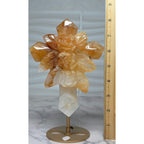 Golden Healer quartz rose cross with stand beside an inch ruler