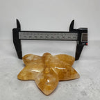 Golden Healer Quartz orchid carving caliper measurement showing ~100mm width