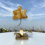 Golden Healer Quartz orchid sculpture on gold stand outdoor display