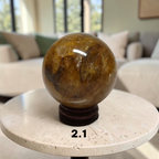 Golden Healer Quartz 2.1 inch sphere on wood stand in living room setting
