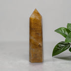 Golden Healer Quartz tower held in gloved hand showing scale
