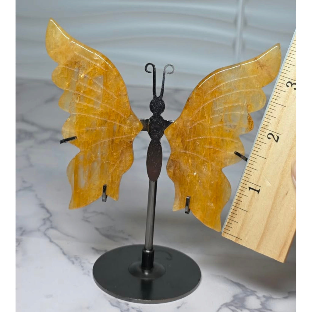Carved quartz butterfly wing shown beside a ruler