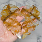 Polished quartz wings with carved feathers and a heart shaped opening