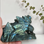 Angled view of labradorite dragon with bright blue flash on its face
