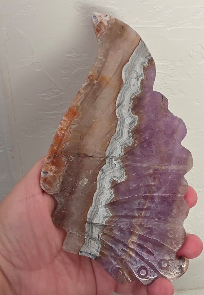 Handheld amethyst lace agate butterfly wing, purple and tan with cream wavy lines