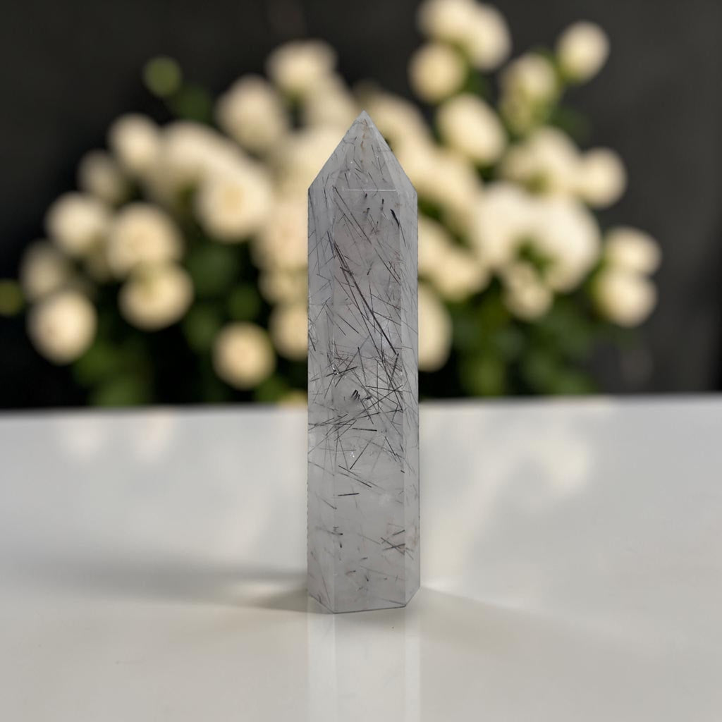 Rutilated quartz obelisk tower in gray with dark needle rutiles and sharp point