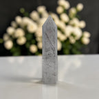 Rutilated quartz obelisk tower in gray with dark needle rutiles and sharp point