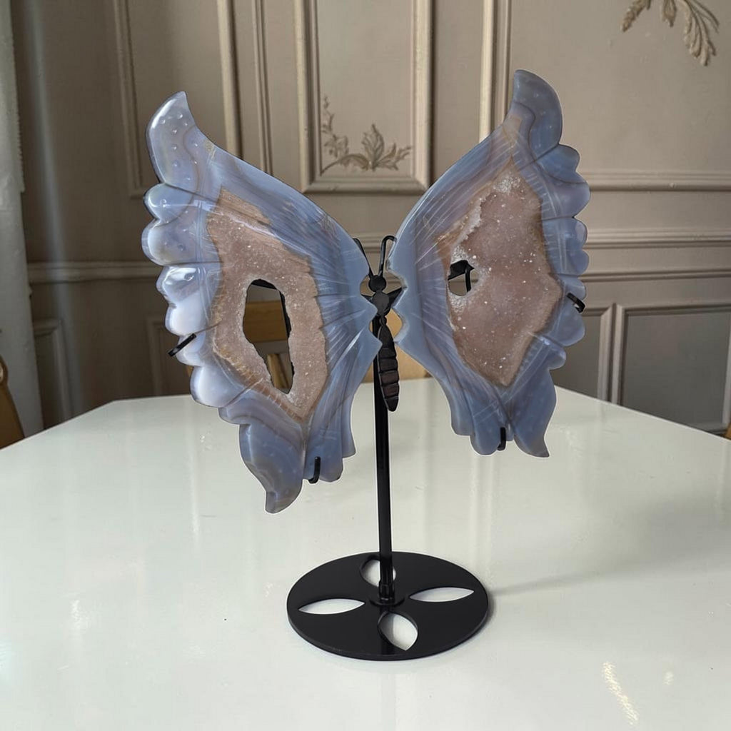 Blue agate butterfly wings crystal sculpture with black stand, angled view
