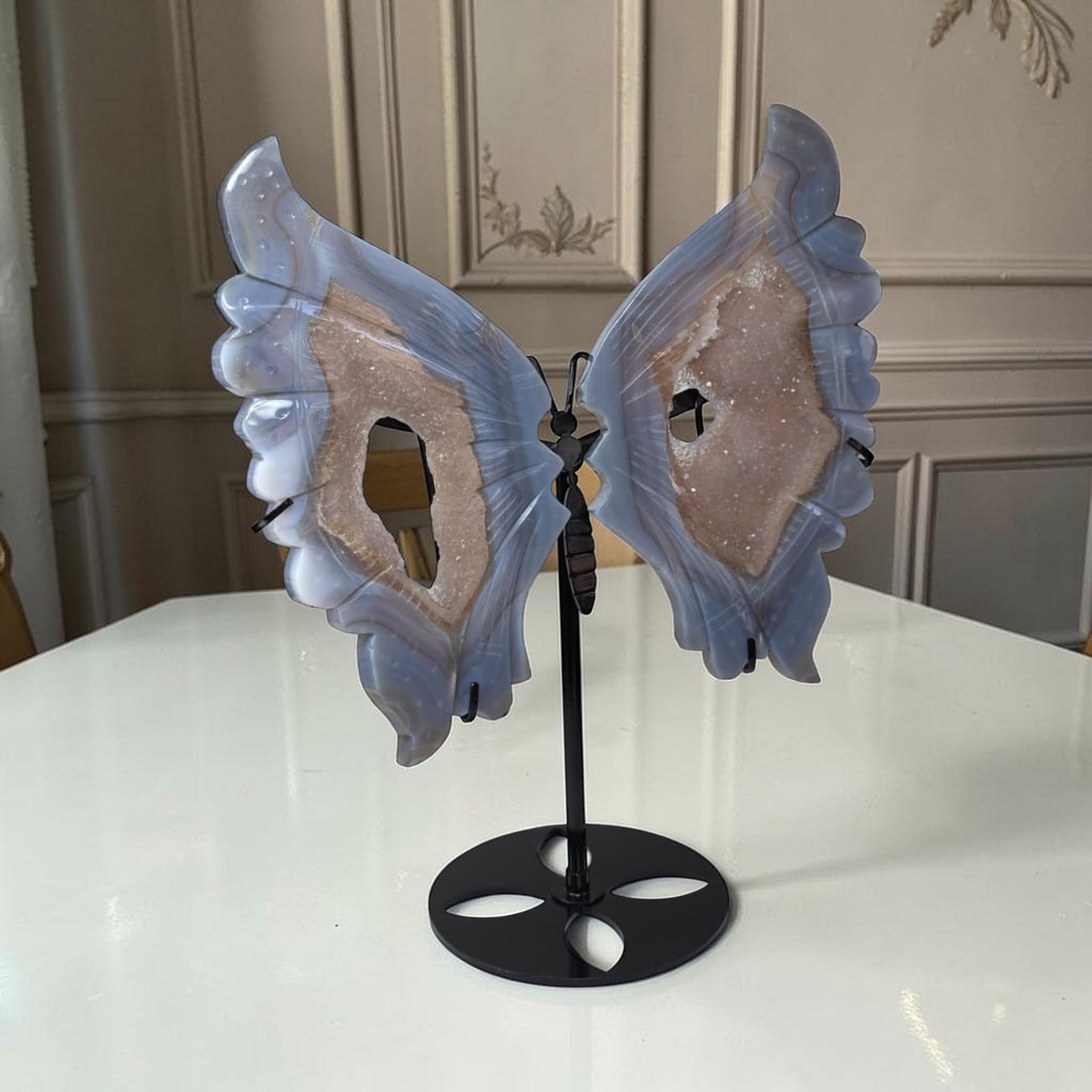 Blue agate butterfly wings crystal sculpture with black stand, angled view