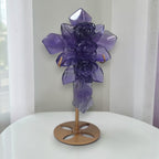 Purple fluorite cross ornament with carved rose details, upright on bronze base