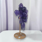 Purple fluorite cross ornament with carved rose details, side view on bronze stand