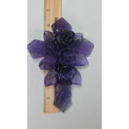 Large purple fluorite cross ornament with carved rose details, beside a measuring ruler