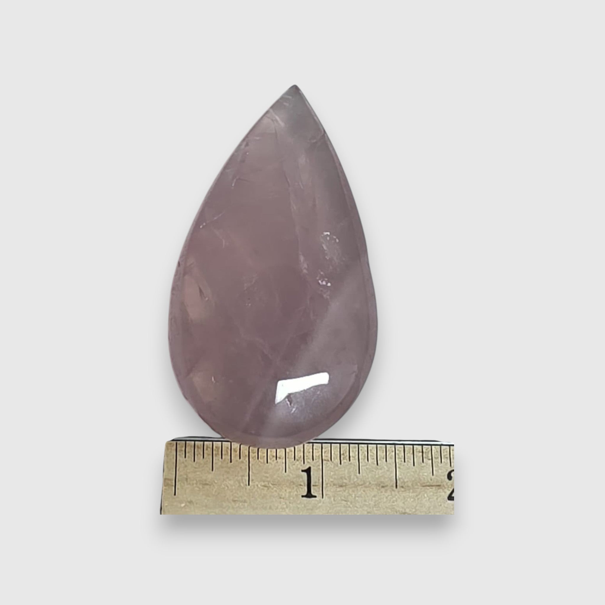 Rose quartz teardrop crystal with ruler measuring length