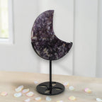 Purple speckled crescent moon crystal decor on black metal stand