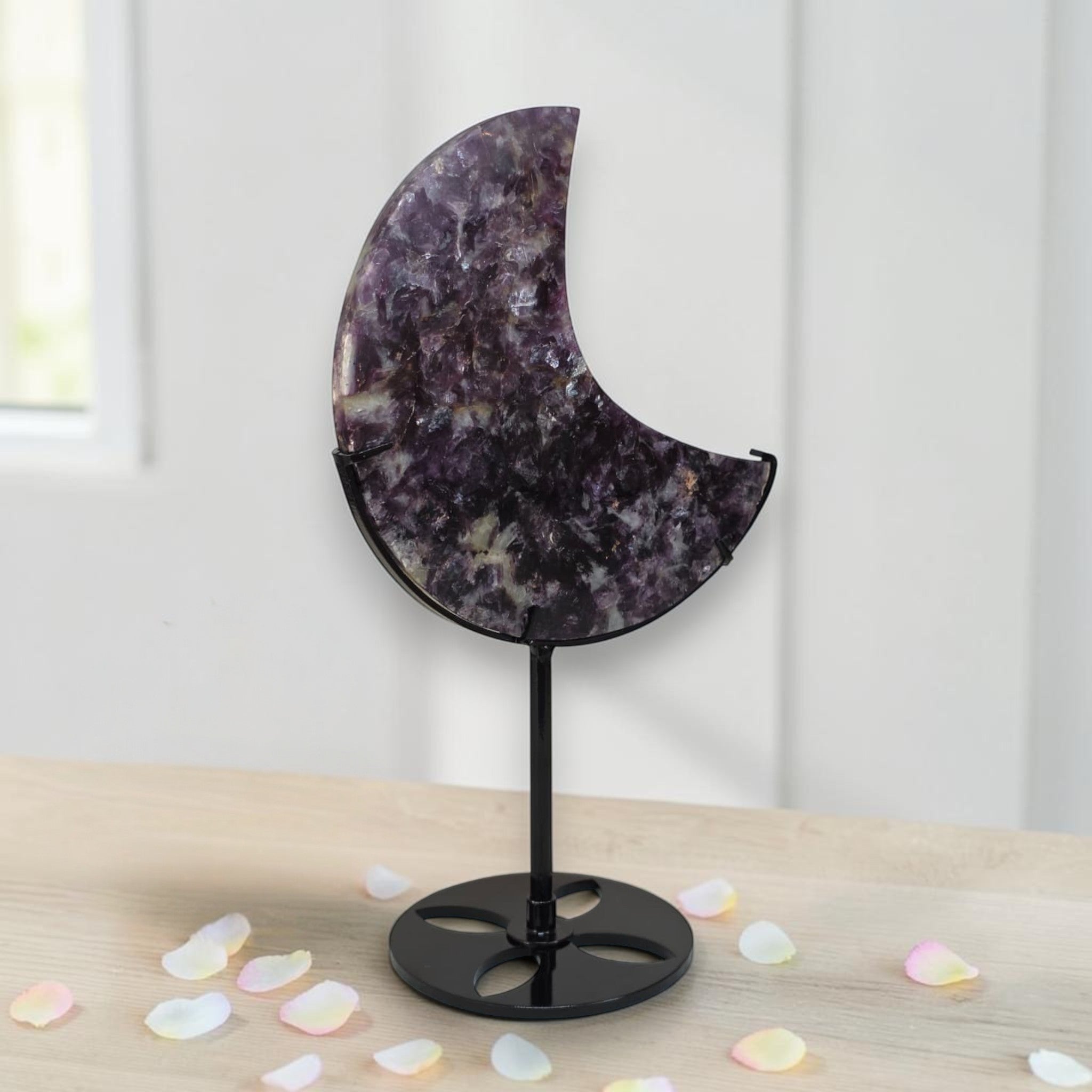 Purple speckled crescent moon crystal decor on black metal stand