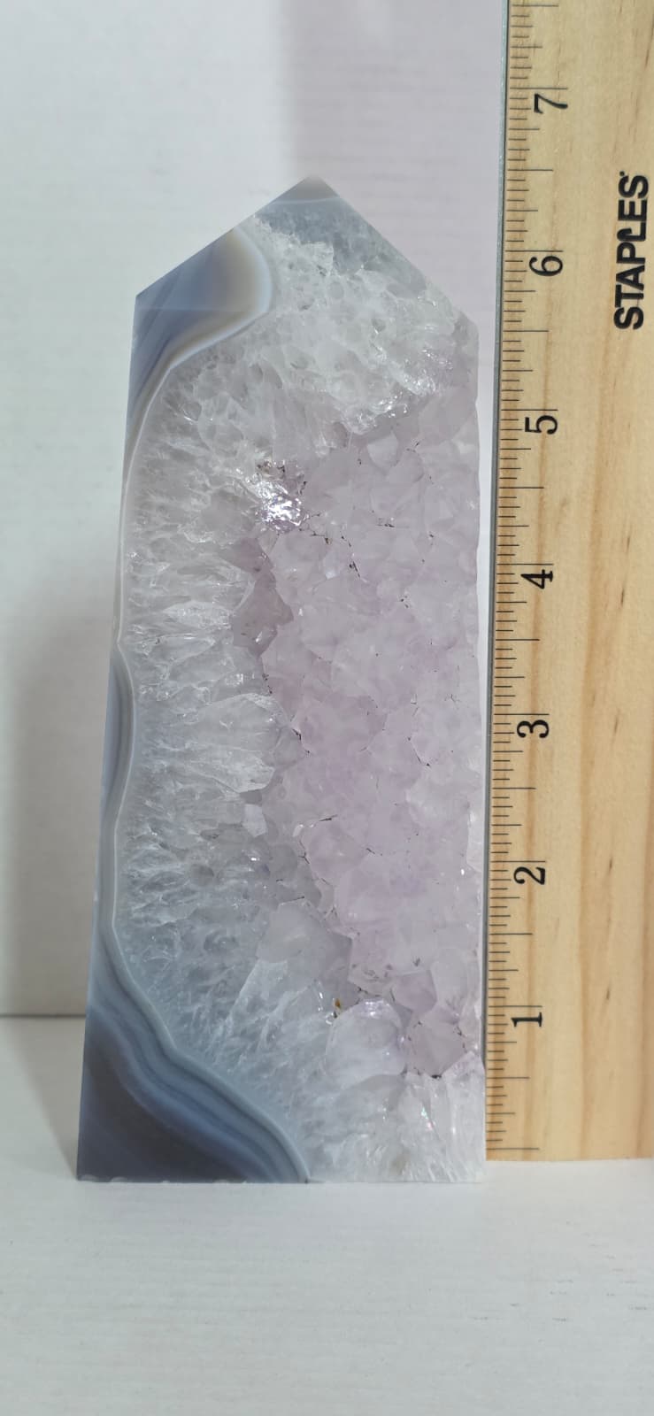 Geode crystal with a ruler for scale on a white background