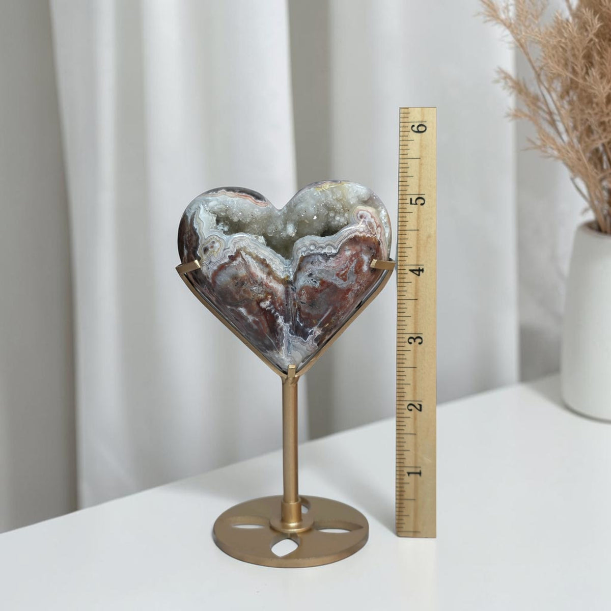Agate heart beside a ruler showing its height with the stand