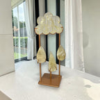 Gold-toned crystal cloud sculpture with three teardrop charms on a square base