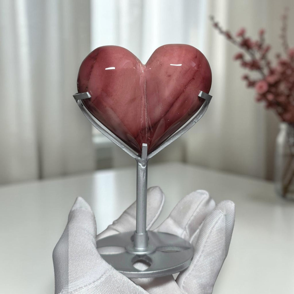 Polished dusty rose and burgundy mookaite jasper heart on a silver tone display stand