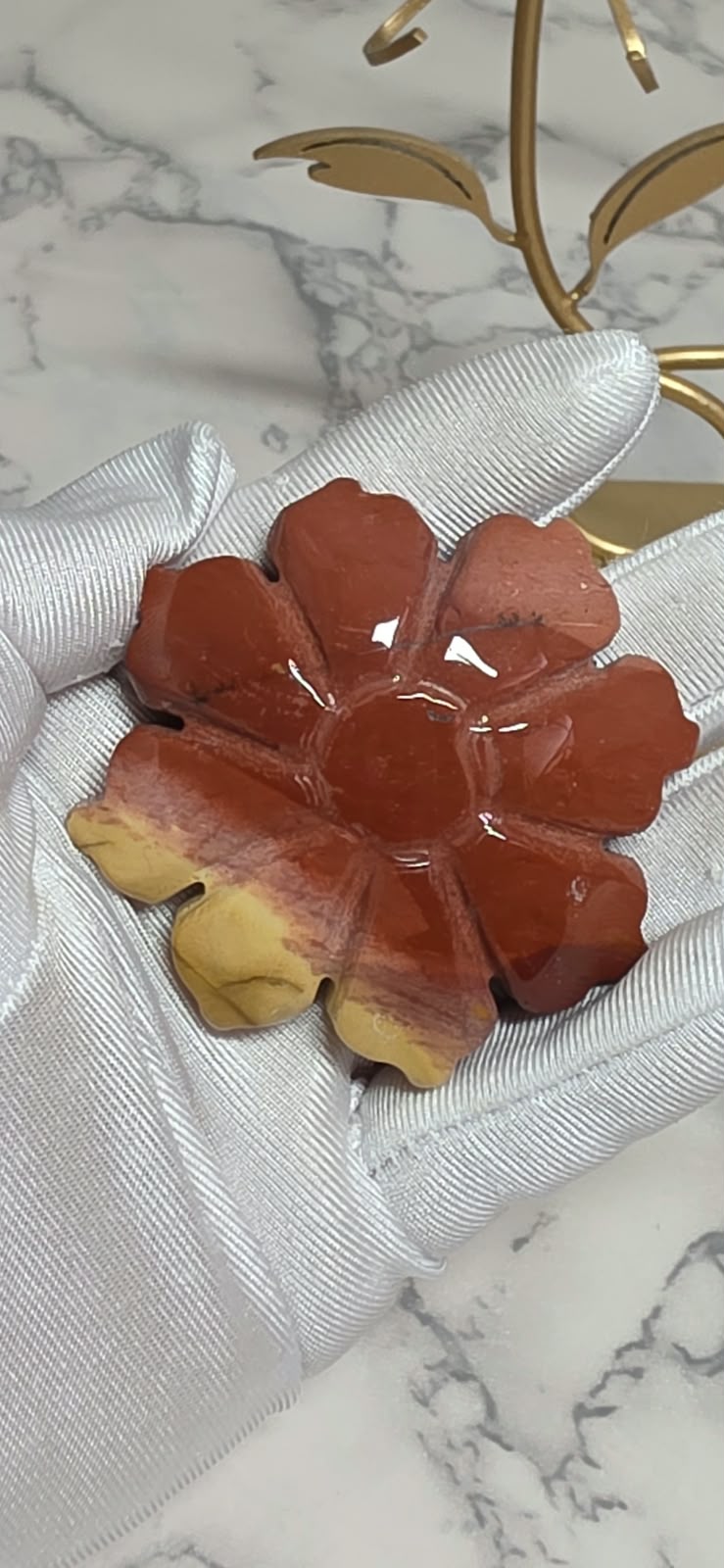 Closeup of reddish Mookaite Jasper rose carving