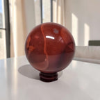 Mookaite jasper sphere, deep red with cloudy bands, glossy finish, 65mm stand