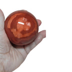 Mookaite jasper sphere detail, orange-red pattern in polished gemstone, 65mm