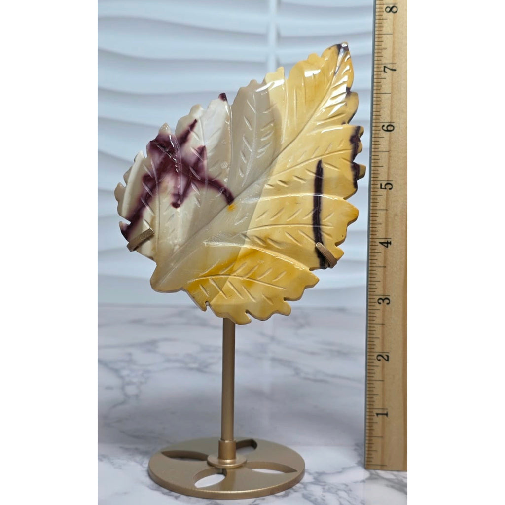 Yellow Mookaite Jasper leaf on stand beside an inch ruler