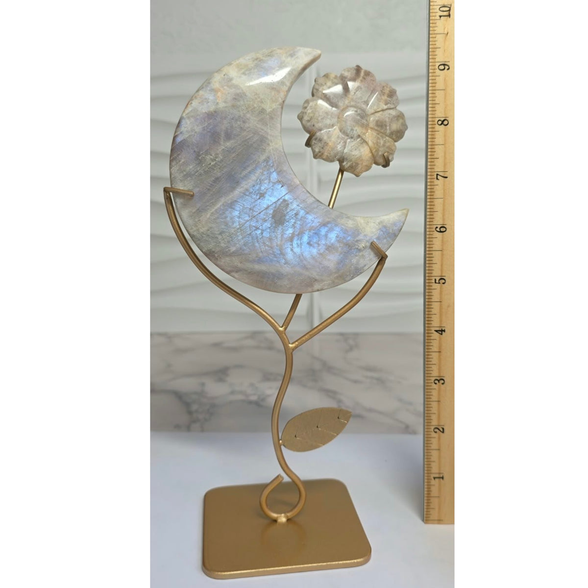 Moonstone crescent moon on stand beside measuring ruler
