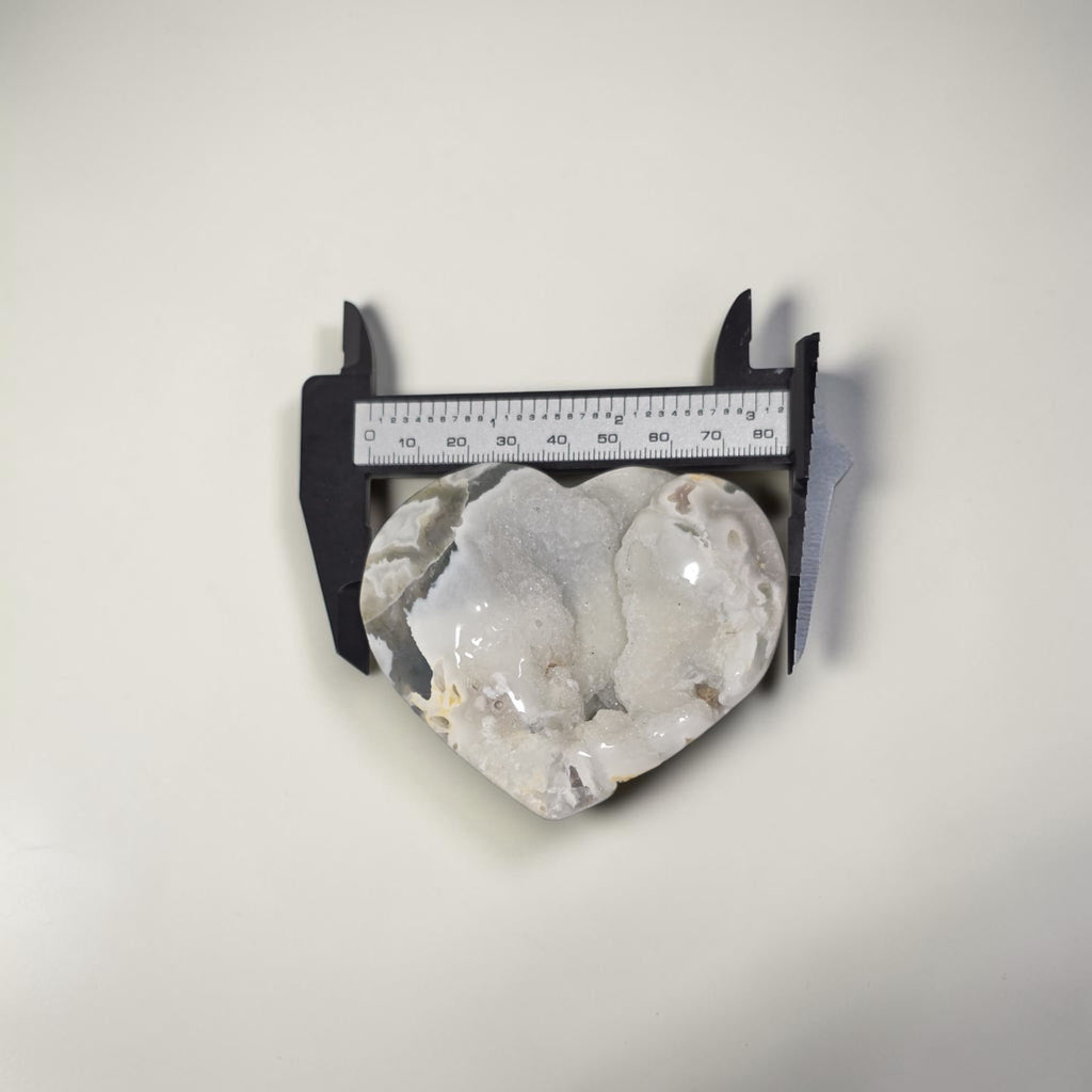 Decorative stone with a caliper for scale on a white background