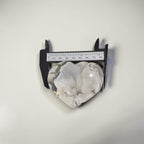 Decorative stone with a caliper for scale on a white background