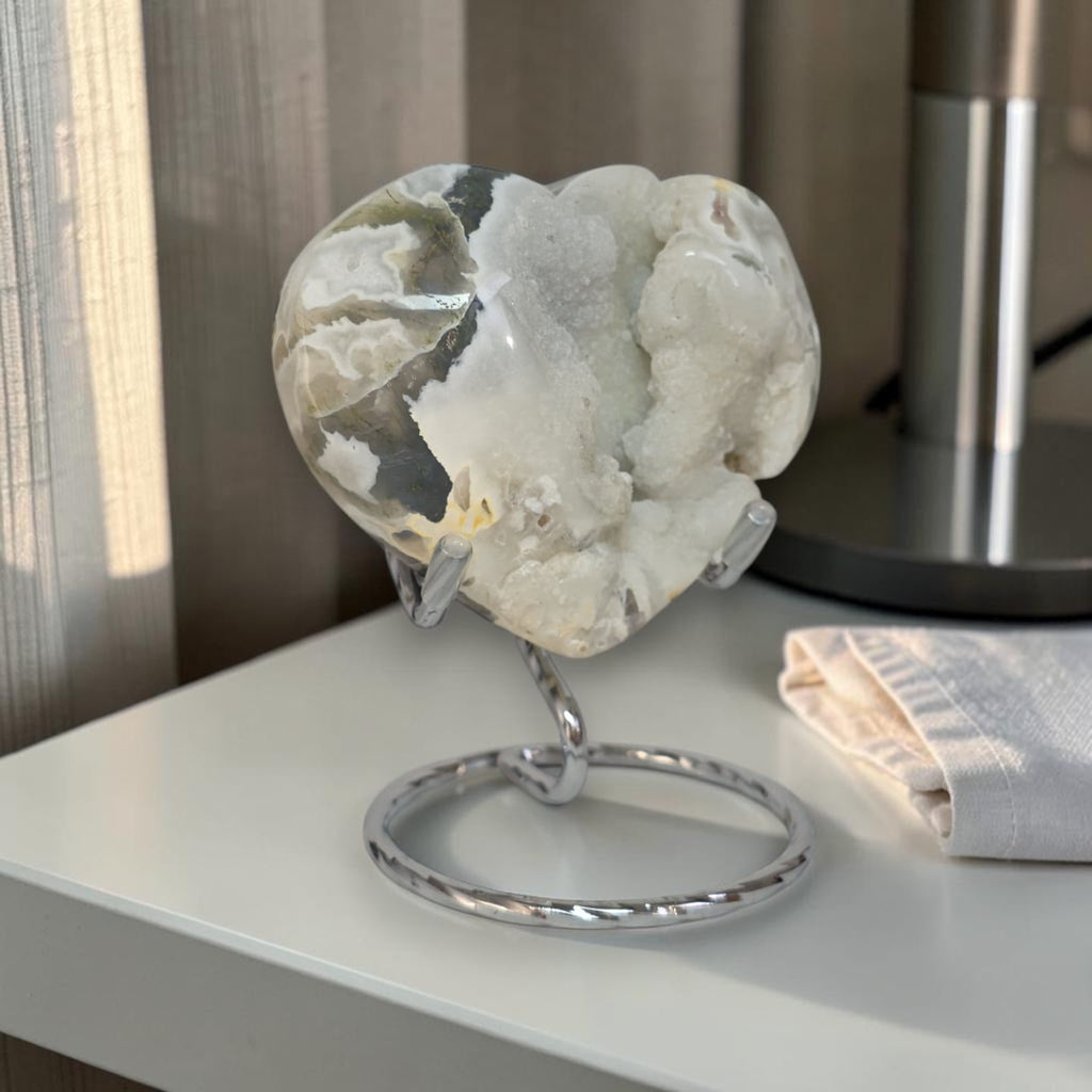 Heart-shaped crystal on a stand with a neutral background