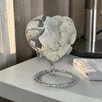 Heart-shaped crystal on a stand with a neutral background