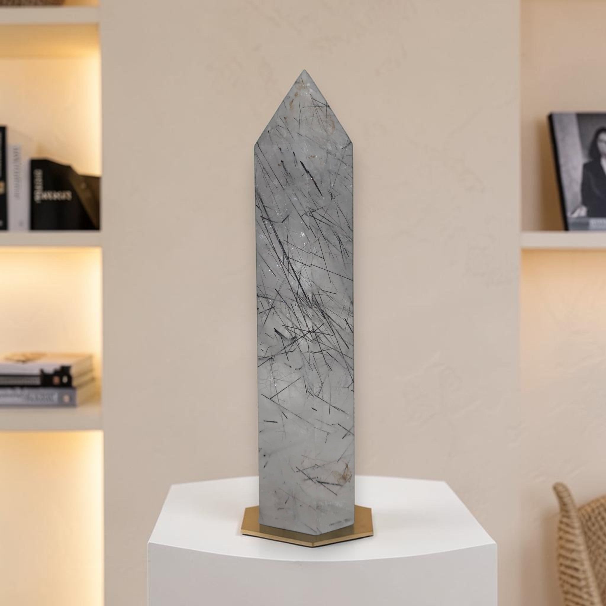 Gray rutilated quartz tower obelisk with dark needle rutiles standing on base