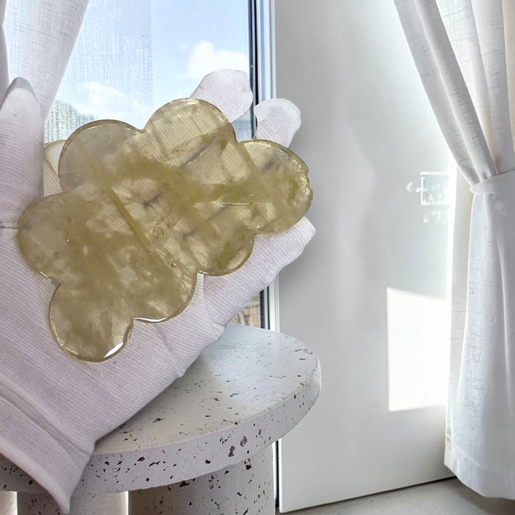 Gloved hand holding a yellow crystal cloud piece with rounded crystal texture