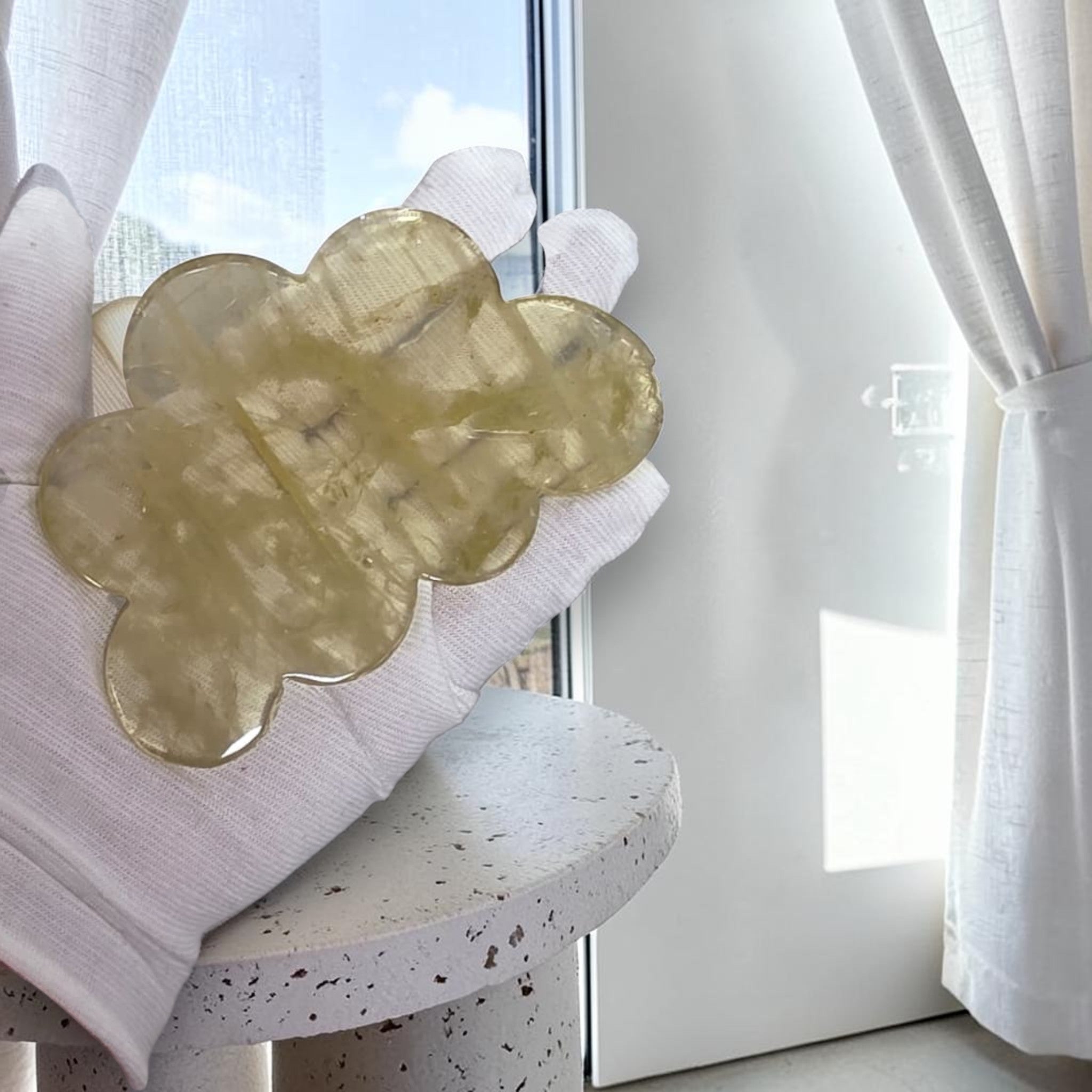 Gloved hand holding a yellow crystal cloud piece with rounded crystal texture