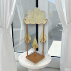 Gold-toned crystal cloud sculpture with hanging teardrop pieces on a display stand