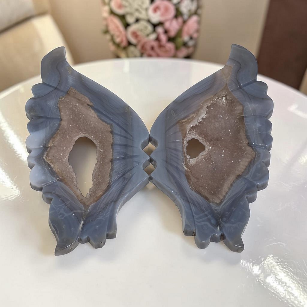 Blue agate butterfly wings crystal sculpture, resting on tabletop