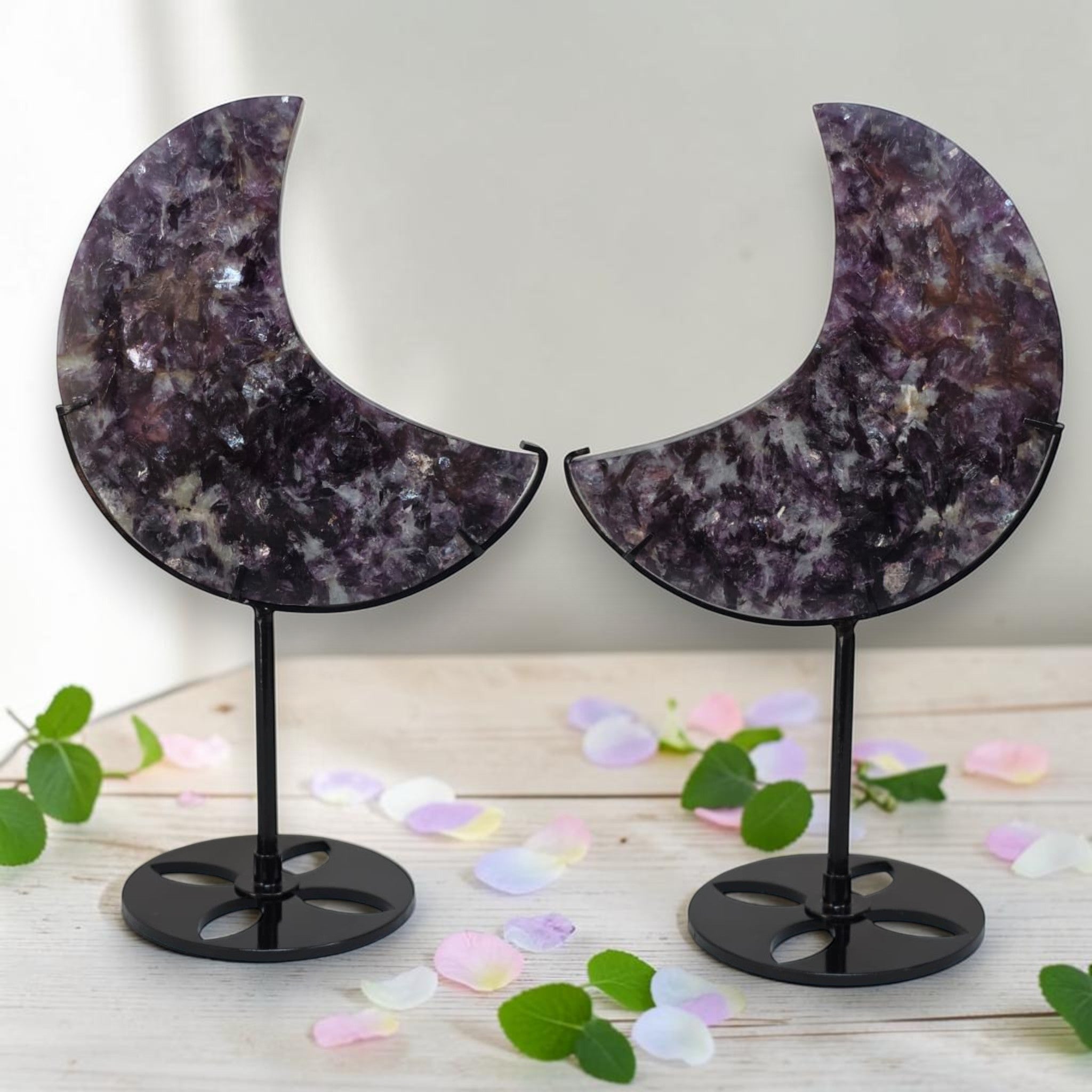 Pair of purple speckled crescent moon crystal decor pieces on black stands