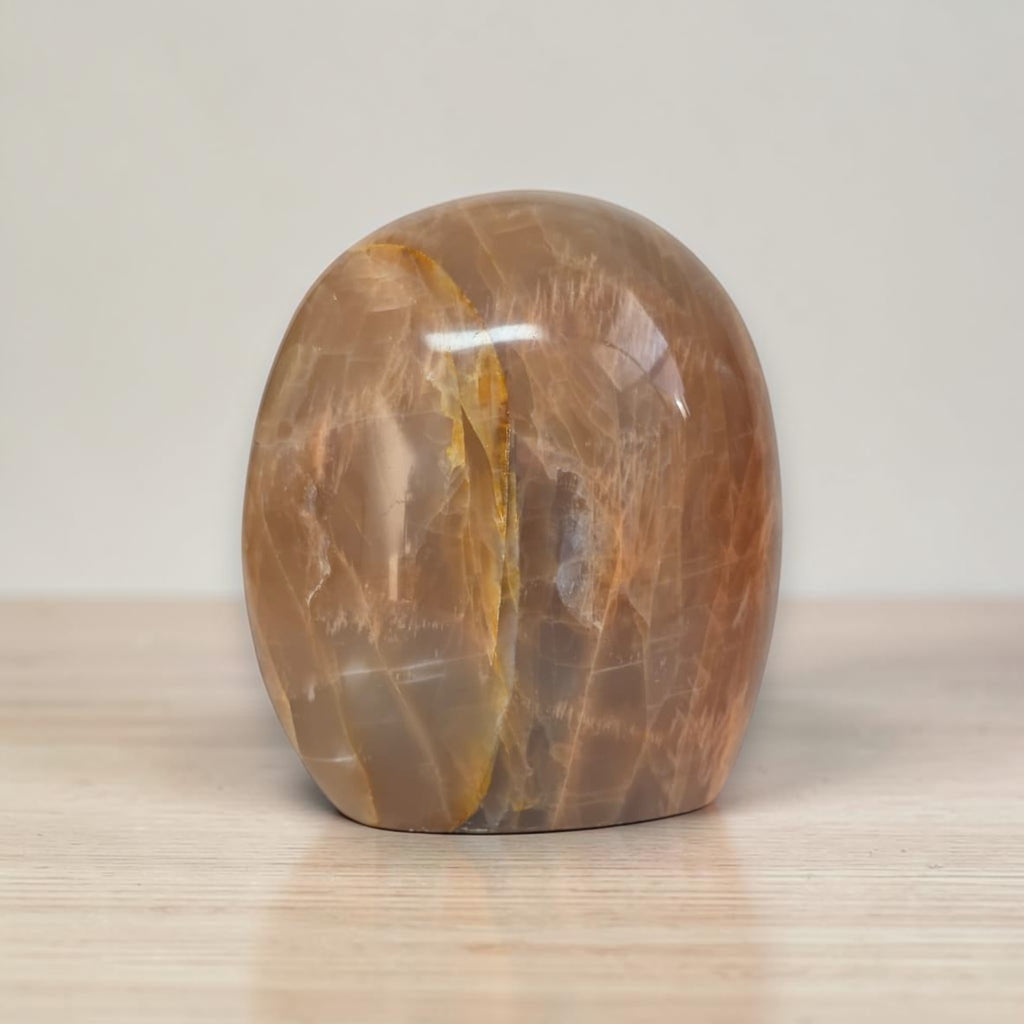 Polished peach-brown freeform crystal palm stone with glossy surface