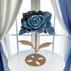 Natural Trolleite rose carving on gold stand on white side table, angled view