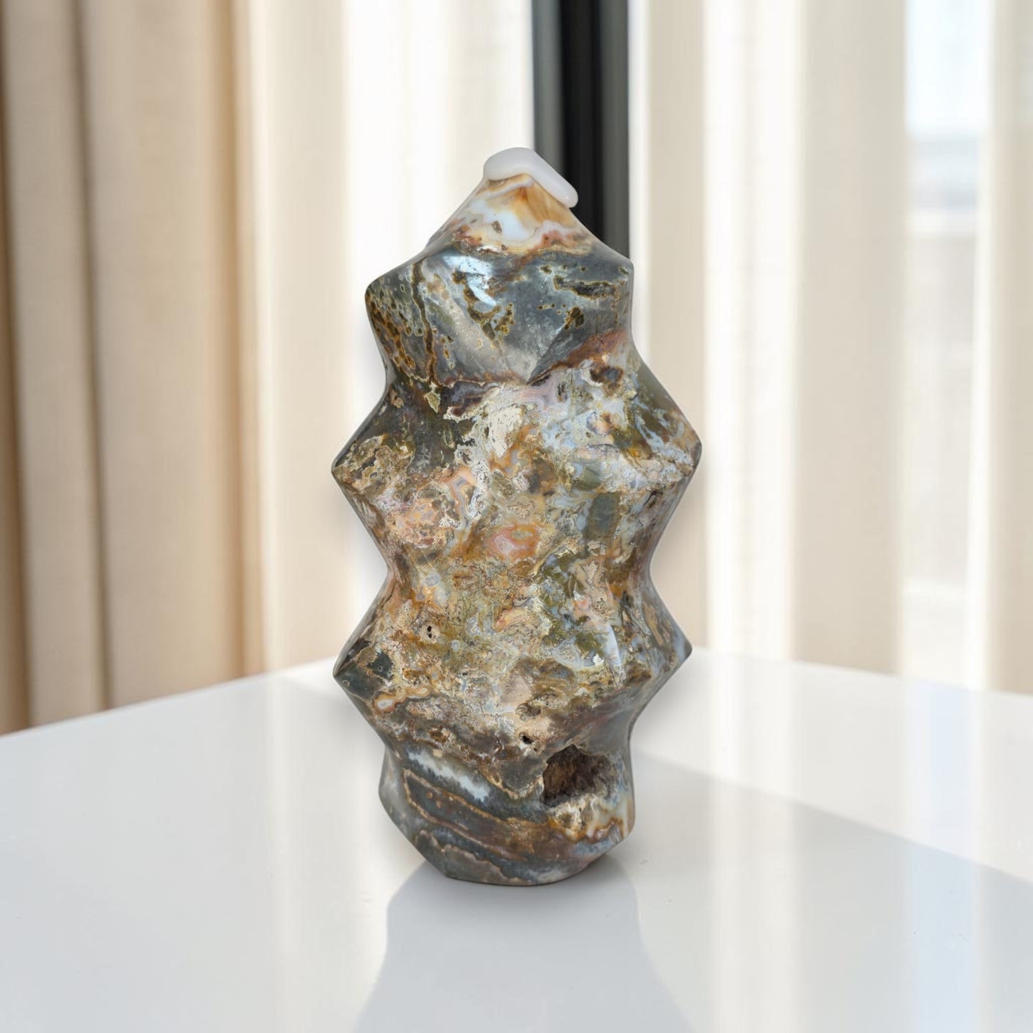 Decorative stone sculpture on a white surface with a neutral background