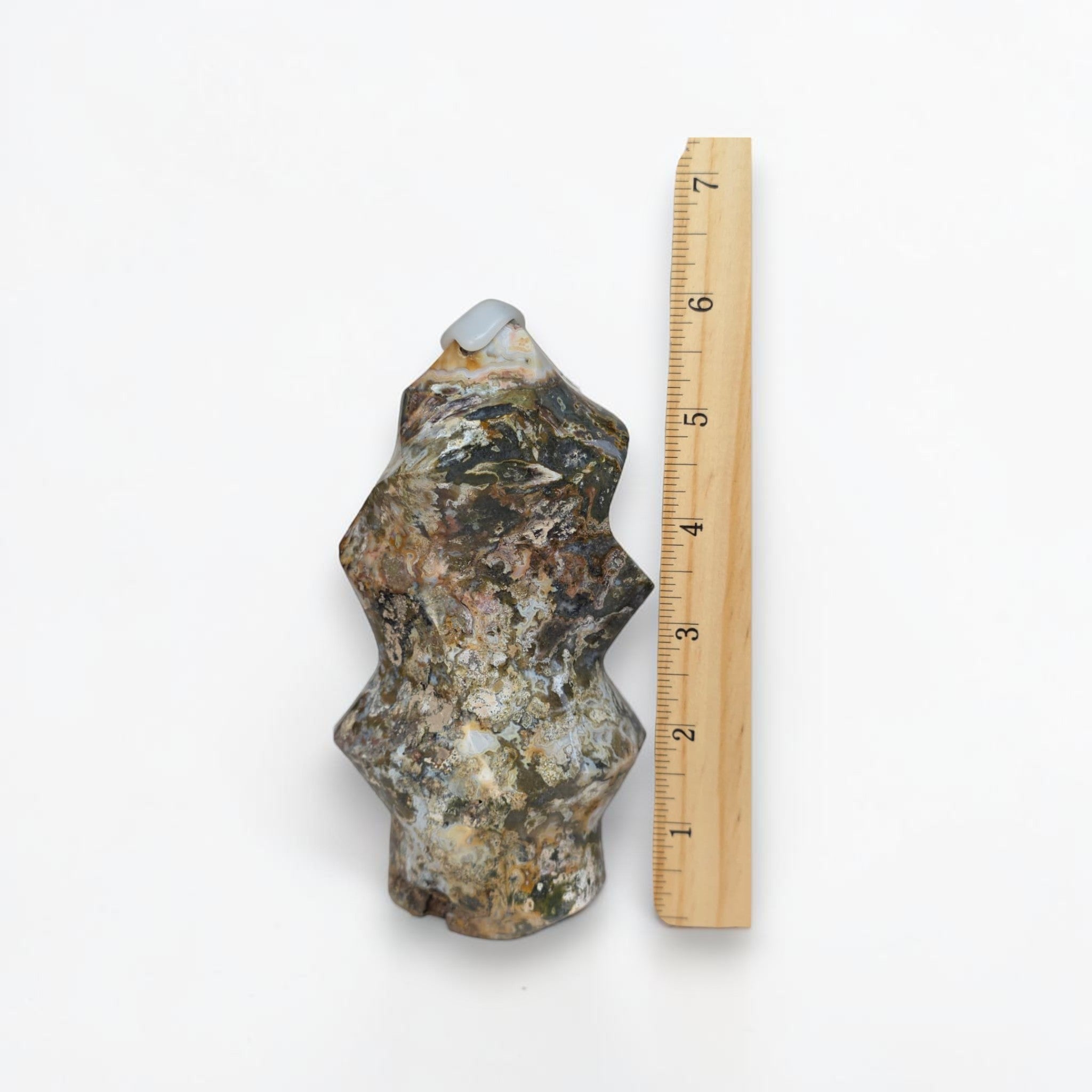 Rock sample next to a ruler on a white background