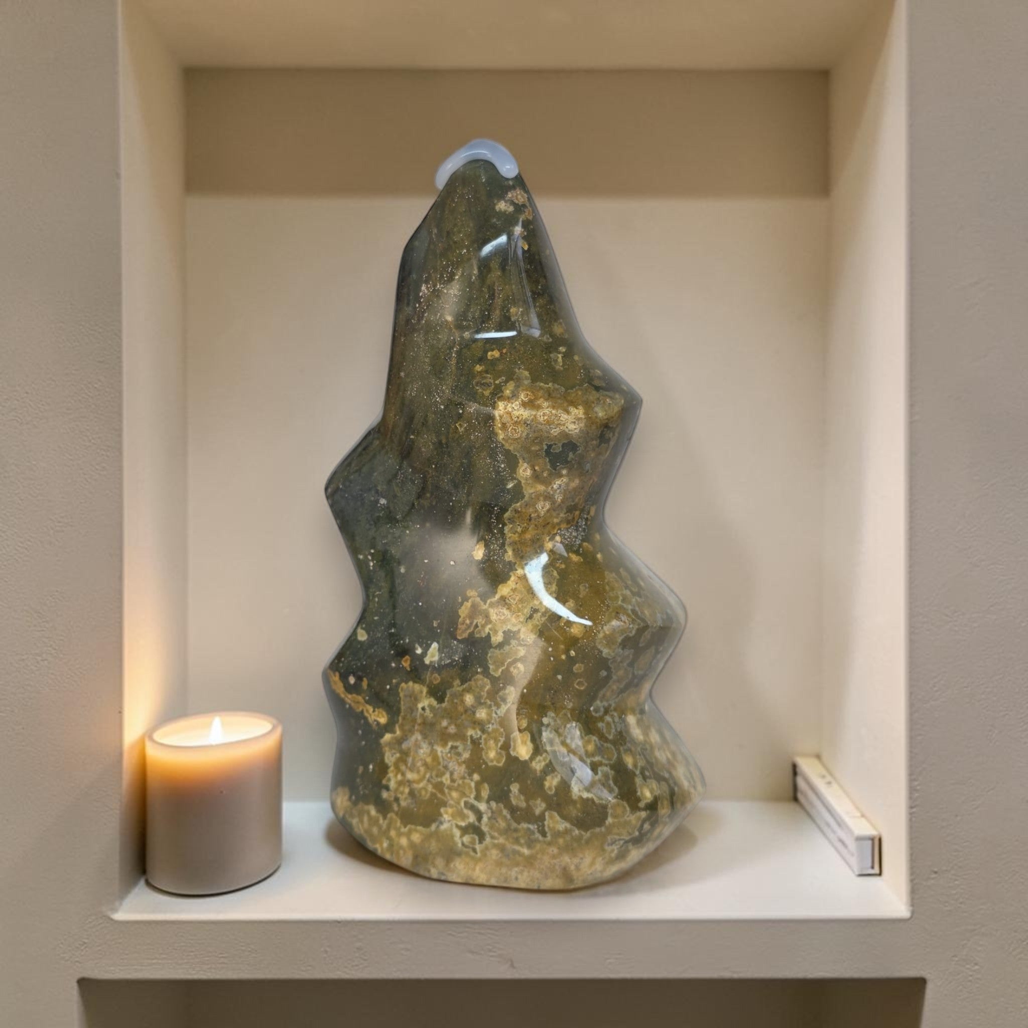 Decorative stone sculpture on a shelf with a candle