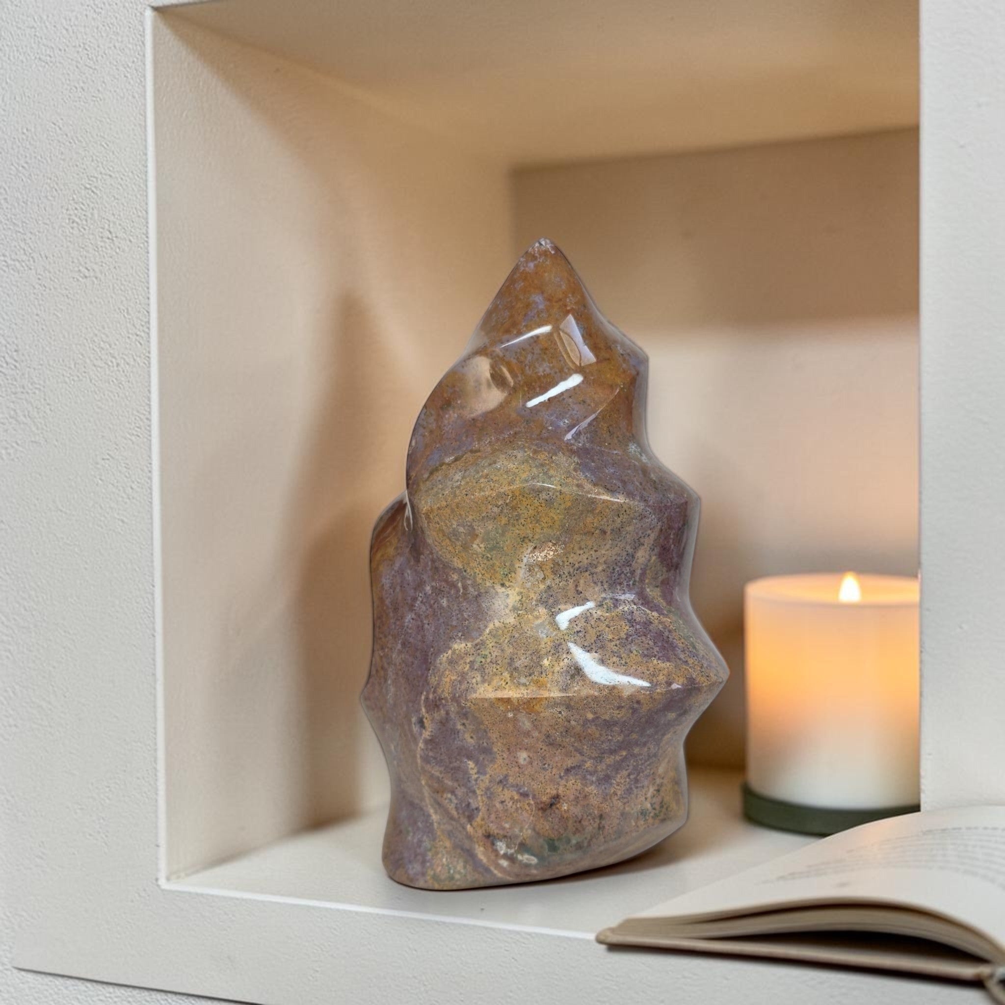 Decorative crystal on a shelf with a candle and book in a softly lit room