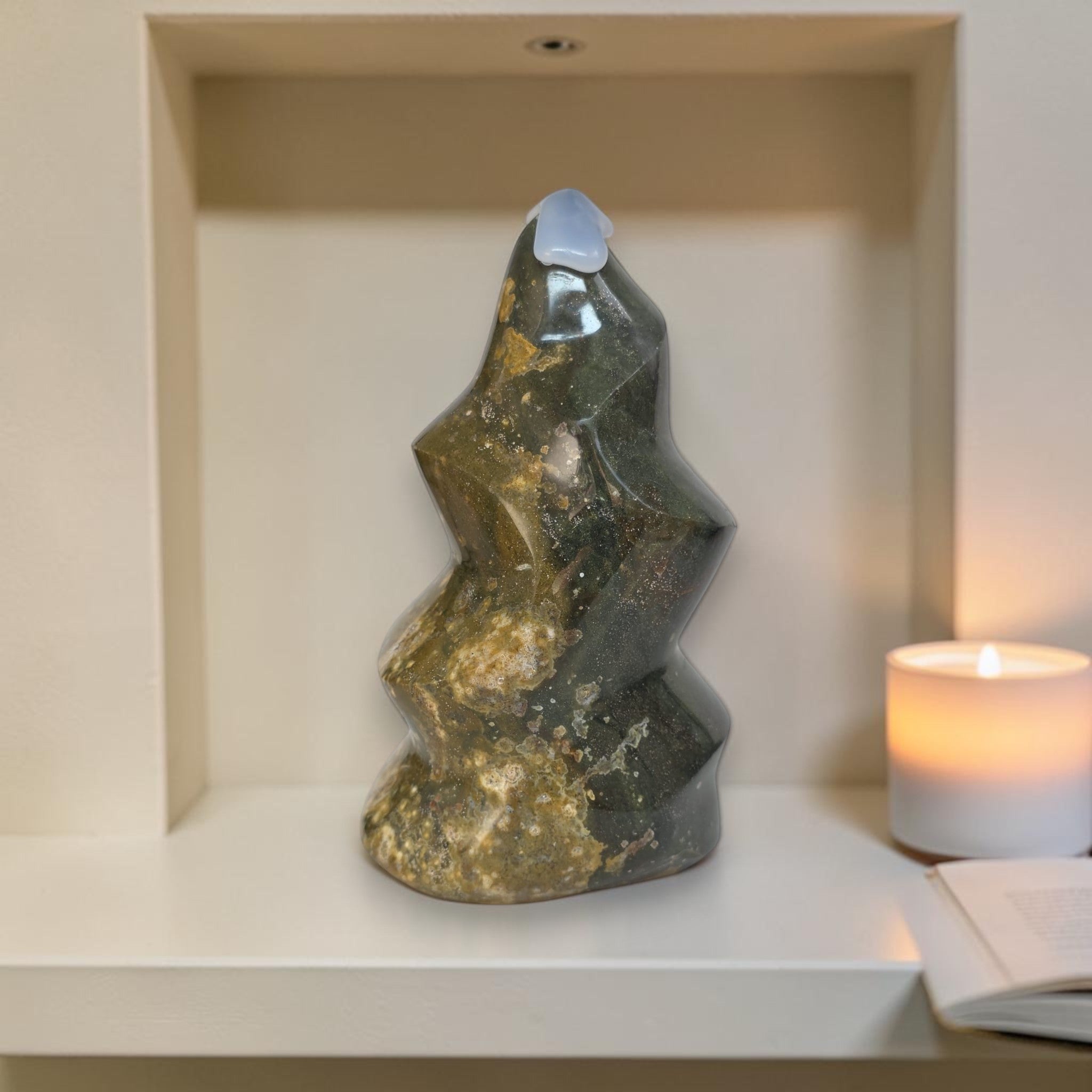 Decorative stone sculpture on a shelf with a candle in the background