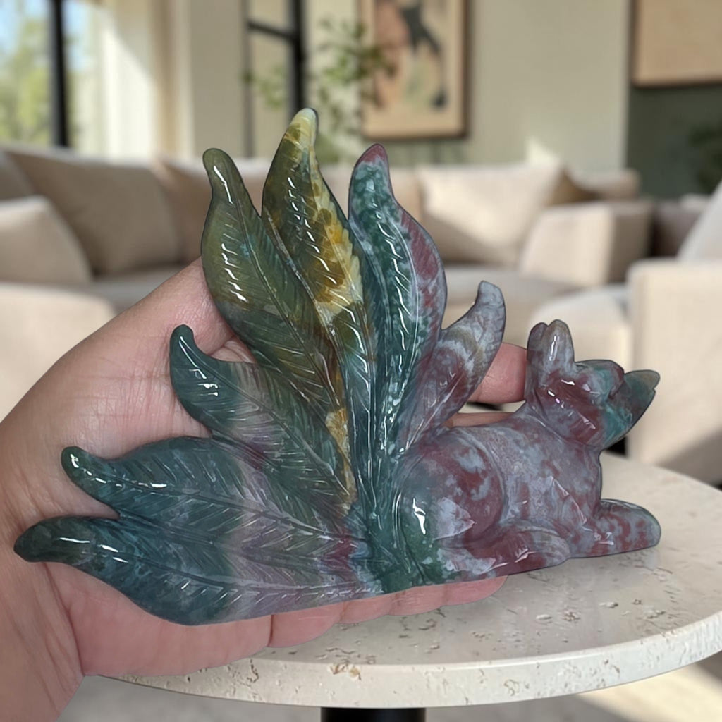 Ocean jasper fox carving held in hand to show scale