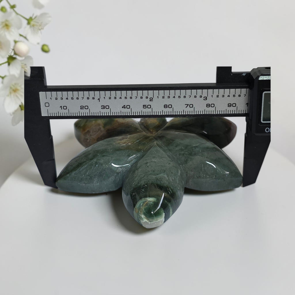 Ocean Jasper orchid carving shown with caliper for size