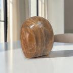 Polished peach-brown freeform crystal stone, rounded base, visible veining