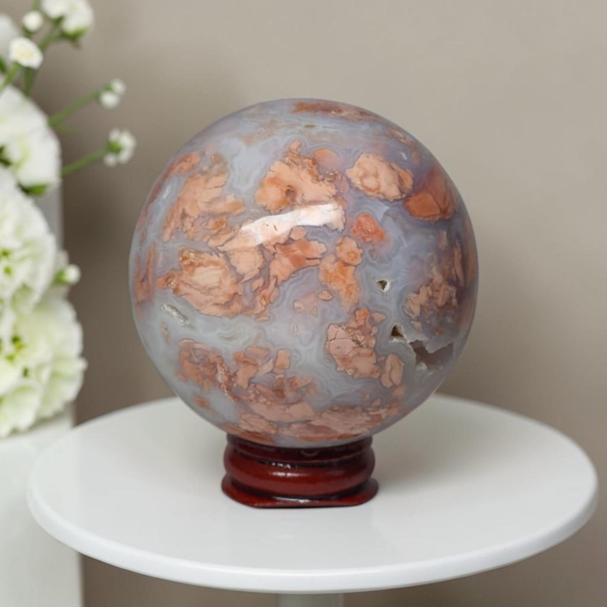 Agate sphere on stand, light blue-gray with orange and beige swirls